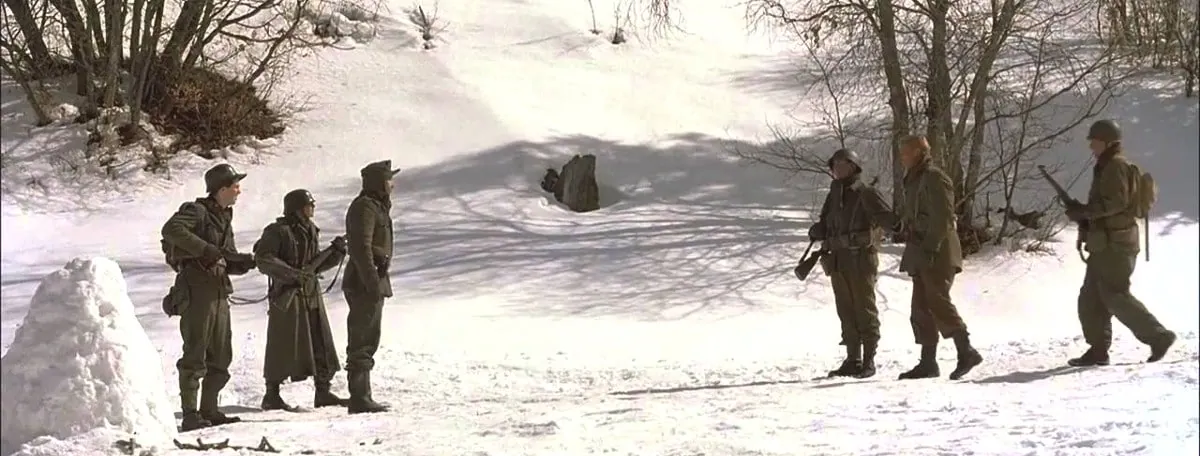 Film still from A Midnight Clear: American soldiers confront German POWs in a snowy forest clearing.