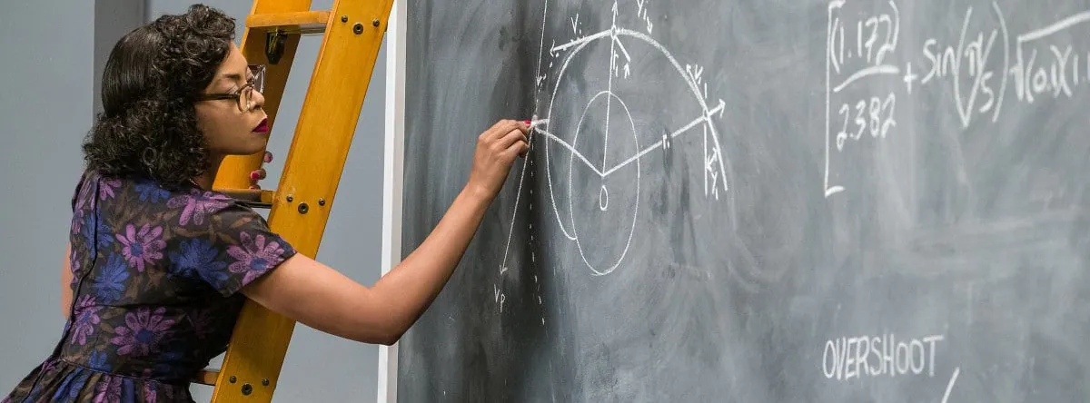Film still from Hidden Figures: Katherine Johnson stands on a ladder, working out equations on a chalkboard.