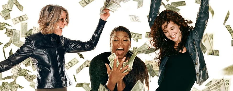 Film still from Mad Money: the three leads celebrate as cash bills fly around them.