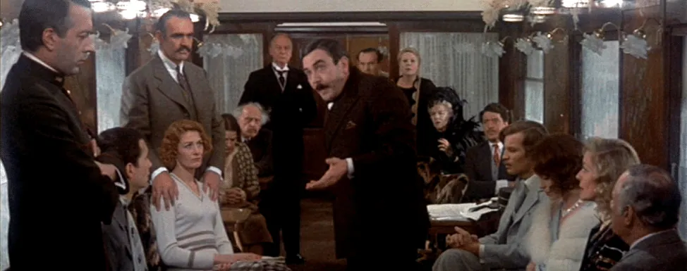 Film still from Murder on the Orient Express: Poirot addresses the assembled train passengers in the dining car.