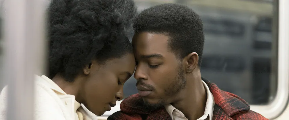 Film still from If Beale Street Could Talk: Tish and Fonny lean forehead to forehead in a tender, intimate moment.