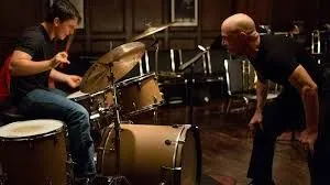Fletcher watching Neiman play during the drum-off scene in Whiplash.