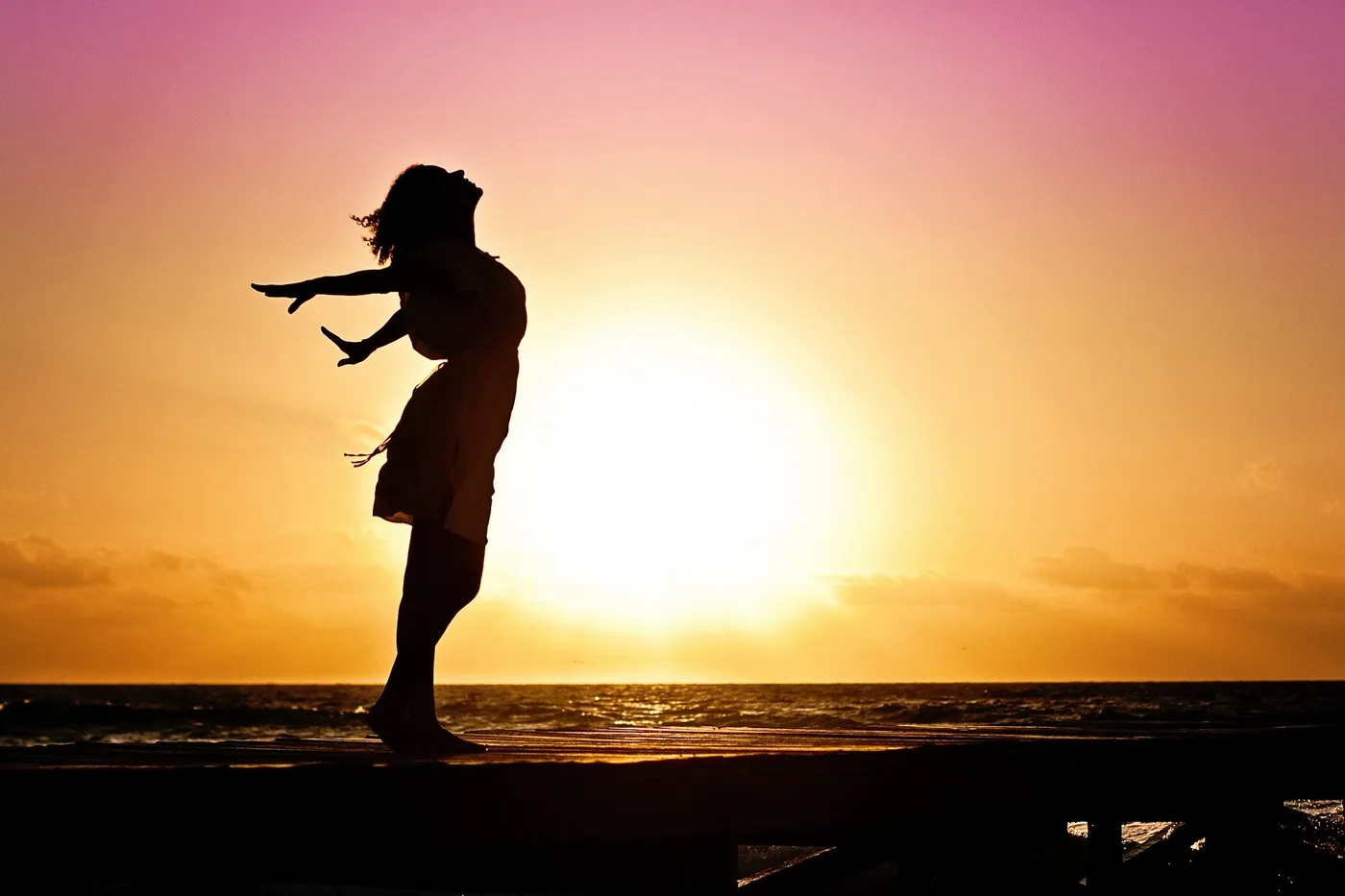 Woman standing in a doorway looking out, framed by warm light, evoking a character on the edge of change.