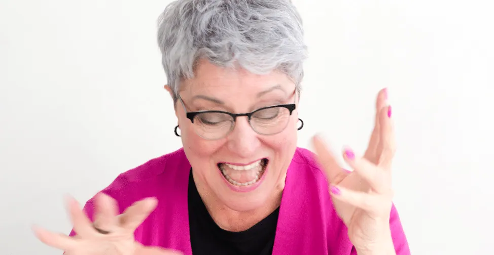A woman laughing with hands raised, for the Editor Roundtable episode "Anne Learns to Write."