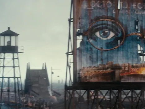 Film still from The Great Gatsby: a watchtower stands beside a weathered billboard painted with a giant pair of eyes overlooking the industrial valley.