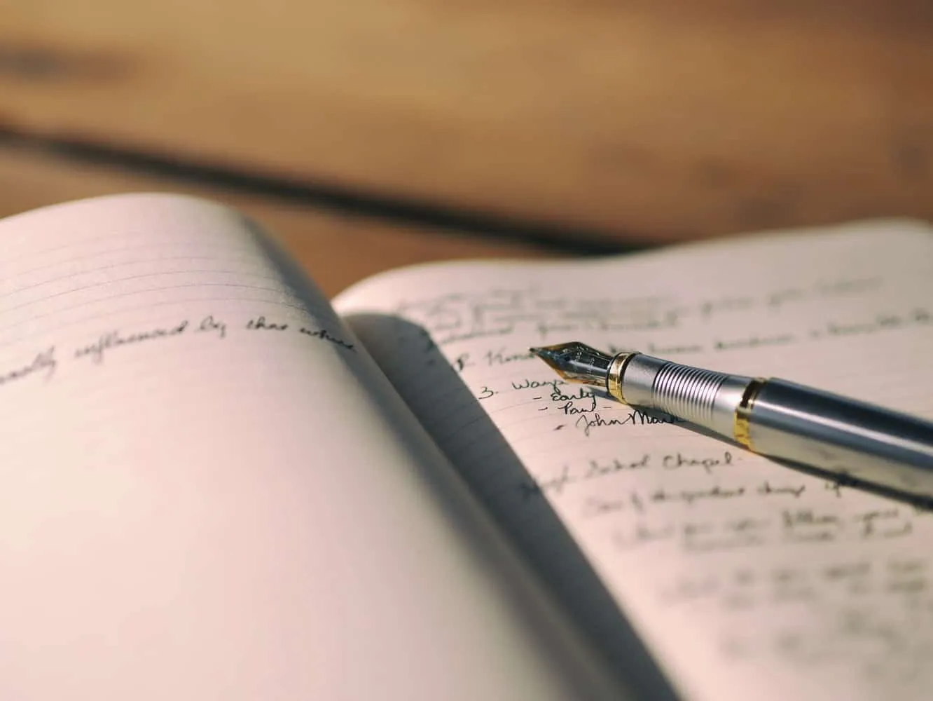 A fountain pen resting on a handwritten journal page.