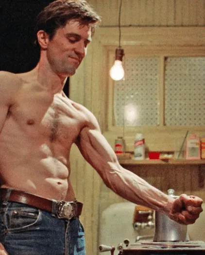 A shirtless Travis Bickle holding his fist over an open gas-stove flame during his self-training montage.