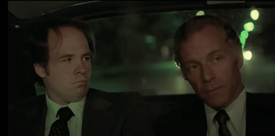 Senator Palantine and an aide riding in the back of Travis's taxi at night.