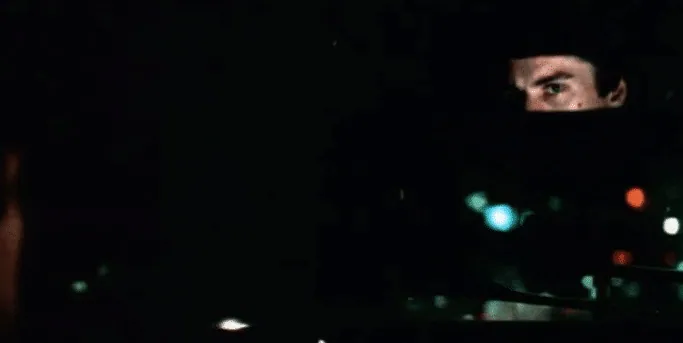 Travis's shadowed face lit by dashboard lights, glancing again at Betsy in his rearview mirror.