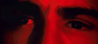 Extreme close-up of a man's eyes lit in red, conveying Taxi Driver's intense psychological tone.