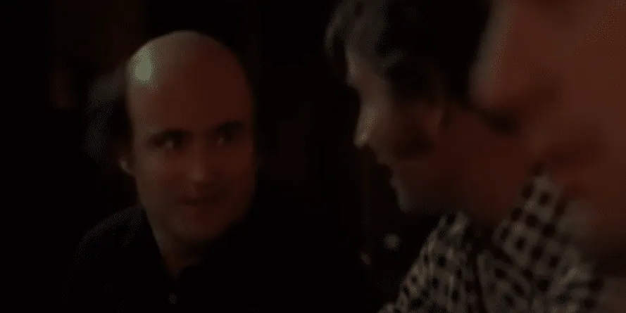 Fellow taxi drivers talking together in a dimly lit diner booth.