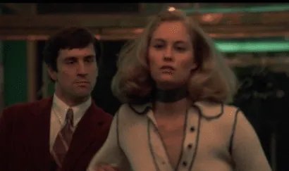 Travis and Betsy standing together outside a movie theater, her expression tense.
