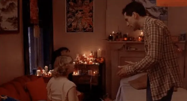 Travis talking with Iris in her candlelit room, trying to persuade her to go home.