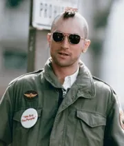Travis, with his mohawk haircut and sunglasses, wearing a Palantine campaign button at the edge of the rally crowd.
