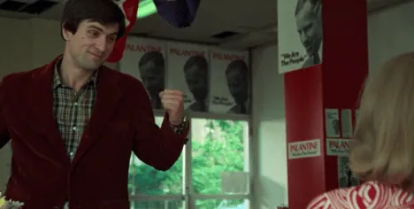 Travis Bickle speaking earnestly to Betsy inside the Palantine campaign office, surrounded by campaign posters.