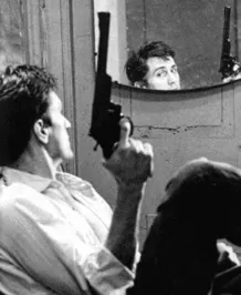 Travis holding a revolver just after a shooting, reflected in a round convex mirror inside a store.