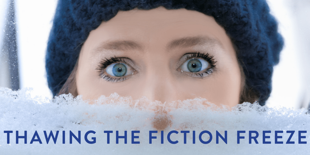 A young blue-eyed woman in a blue knit hat, staring through a snow-covered window looking a bit shocked